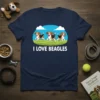 I LOVE BEAGLES text with three running cartoon beagle dogs on a navy blue t-shirt