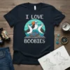 I Love Boobies T-Shirt design featuring three booby birds standing on rocks with a sunset graphic
