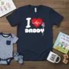 Navy blue t-shirt with "I Love Daddy" text, a red heart with a white heartbeat line, and colorful balloons