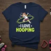 I Love Hooping T-Shirt with a cartoon cat actively hooping, vibrant text, and athletic accessories