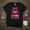 I Love My Crab text with a pink crab graphic wearing a bow and heart accents on a black t-shirt