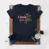 Navy blue t-shirt with pink and gold glitter text that reads "I love sparkles" and festive starburst graphics