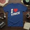 Blue t-shirt with white text "I" and "VINCE" surrounding a red heart graphic, stating "I Love Vince"