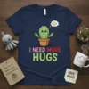 Cute cactus with arms outstretched and "I Need More Hugs" text, perfect for plant lovers