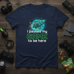 I paused my GAME to be here gamer t-shirt with a rocket graphic and pixelated text