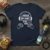 Navy t-shirt with white text "I Paused My Game To Be Here" and graphics of headphones and game controllers