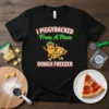 T-shirt with text "I Piggybacked From A Pizza Dough Freezer" featuring cartoon pineapple and pizza characters