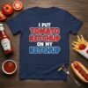Navy t-shirt with white, red, and blue text that reads "I PUT TOMATO KETCHUP ON MY KETCHUP" in bold lettering