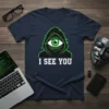 Navy t-shirt with "I See You" text and a glowing green eye within a hooded figure graphic