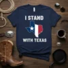 Navy blue t-shirt with white text "I STAND WITH TEXAS" above and below a graphic of the Texas state outline