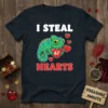 I STEAL HEARTS 67 text with a cute green chameleon holding hearts on a navy t-shirt