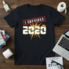 Black t-shirt with bold white text "I SURVIVED 2020" inside a red distressed rectangle, featuring yellow sunburst graphic and a