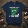 I Survived My Trip To Arkansas t-shirt design featuring state outline, hiker, mountains, river, and campfire graphic