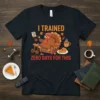 Funny Thanksgiving t-shirt with text "I TRAINED ZERO DAYS FOR THIS" and a cartoon turkey relaxing with pie and remote