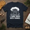 I Turn Trees Into Things quote on a navy blue t-shirt, featuring a tree with shelves of tools and wood