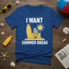 I WANT SUMMER BREAK text with beach castle, surfboard, and sun graphic on a blue t-shirt
