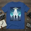 I Want To Believe slogan with three figures looking at a UFO beam on a dark blue t-shirt design