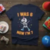 I Was 6 Now I'm 7 Dinosaur Skeleton Birthday T-Shirt, featuring a cartoon skeleton T-Rex wearing a party hat