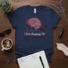 T-shirt design with text "I Wear Burguany For HEADACHES AWARENESS," featuring a brain graphic, burgundy ribbon, heartbeat line, and supportive