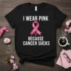Black t-shirt with white text "I Wear Pink Because Cancer Sucks" and a pink breast cancer ribbon graphic