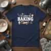 Navy t-shirt with white text "i'd rather be BAKING" and baking graphics like a whisk, cupcake, rolling pin, and flour