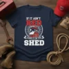 Tractor and barn graphic with text "If It Ain't Red Leave It In The Shed" on a navy blue t-shirt