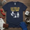 T-shirt with yellow text "IF AT FIRST YOU DON'T SUCCEED CALL DAD" and cartoon graphic of two men fixing a