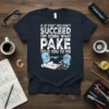 T-shirt with the quote "If At First You Don't Succeed Try Doing What Pake Told You To Me" featuring cartoon