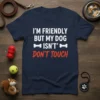 Navy blue t-shirt with white text "I'M FRIENDLY BUT MY DOG ISN'T" and red text "DON'T TOUCH", featuring bone graphics
