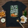T-shirt with white text "I'm Just Here For The Jalapeno Poppers" and illustration of jalapeño poppers on a plate