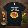 Black t-shirt with white text "I'M JUST HERE FOR THE CHIPS & SALSA" above a bowl of salsa surrounded by