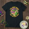 T-shirt design with text "I'm Just Here For The King Cake" featuring a cartoon alligator holding a king cake