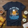 I'm Just Here For the Latkes Hanukkah t-shirt with a stack of pancakes and menorah graphic