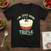 Black t-shirt featuring a colorful graphic of a trifle bowl with the text "I'm Just Here For The Trifle" above