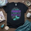 I'm Kinda PISSED I'm NOT A MERMAID text design with mermaid tail graphic and purple/teal colors on a navy t-shirt