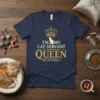 T-shirt with gold text "I'm My Cat Servant Queen She Acts Like A" above a crown and cat graphic