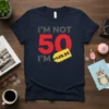 "I'm Not 50 I'm $49.95" humorous birthday t-shirt with bold red number 50 and a price tag graphic