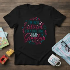 Black t-shirt with "I'm Not Retired I'm A Full-Time Grandma" text in decorative font, surrounded by floral elements