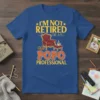 I'm Not Retired I'm A Popo Professional text with illustration of armchair and coffee cup on blue t-shirt