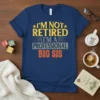 I'm Not Retired I'm A Professional Big Sis quote on a navy blue t-shirt, featuring distressed yellow and orange typography