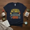 Navy t-shirt with yellow and orange text reading "I'm Not Retired I'm A Professional Gigi" and cartoon graphics of family