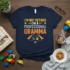 I'm Not Retired I'm A Professional Gramma text with superhero cape graphic on navy t-shirt