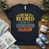 I'm Not Retired I'm a Professional Mamaw quote t-shirt in yellow, grey, and orange distressed text