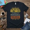 I'm Not Retired I'm A Professional Mamma text design on a black t-shirt, featuring yellow and orange typography with decorative