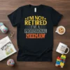 Black t-shirt with bold yellow and orange text reading "I'm Not Retired I'm A Professional Meemaw"