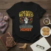 I'm Not Retired I'm A Professional Mimzy t-shirt with a juggling raccoon wearing a crown and glasses. Features yellow and