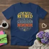 T-shirt with text "I'm Not Retired I'm A Professional Mommom" in distressed yellow, gray, and orange font, featuring stars and