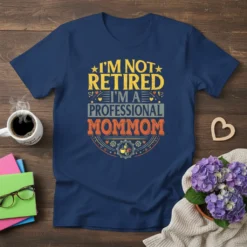 T-shirt with text "I'm Not Retired I'm A Professional Mommom" in distressed yellow, gray, and orange font, featuring stars and
