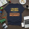 Navy t-shirt with yellow and orange text: "I'M NOT RETIRED I'M A PROFESSIONAL MOMMY"
