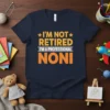 I'm Not Retired I'm A Professional Noni text design on a navy blue t-shirt, featuring orange and yellow typography